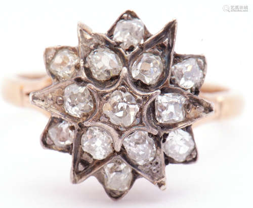 Antique diamond star cluster ring featuring 13 old mine cut diamonds in claw and grain settings,