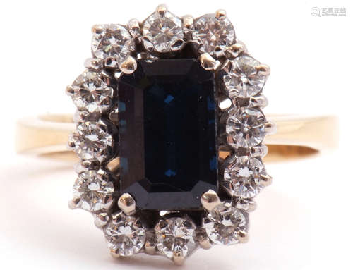 Precious metal sapphire and diamond cluster ring, the rectangular cut sapphire set within a border