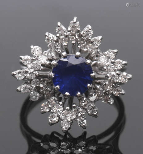 Sapphire and diamond cluster ring, a snowflake design centring a round cut faceted sapphire (7mm