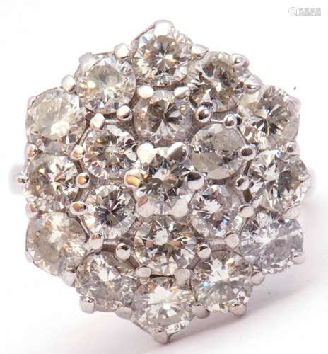 Diamond cluster ring, the circular panel set with three tiers of round brilliant cut diamonds,