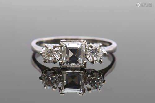 Diamond three-stone ring featuring a square step cut diamond, 1ct approx, flanked by two round