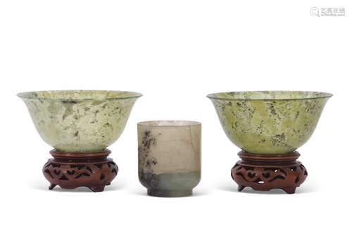 Two spinach green jade small bowls on wooden bases, together with a further small jade cup (3)