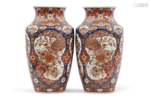 Pair of Japanese porcelain vases with Imari type design in panels with flowers on a blue ground,