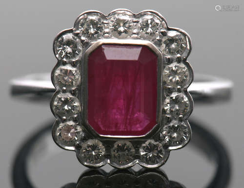 18ct white gold, ruby and diamond cluster ring, the rectangular cushion cut ruby bezel set and