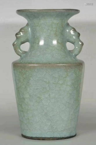 A Chinese vase with lite green and two dragon handles.