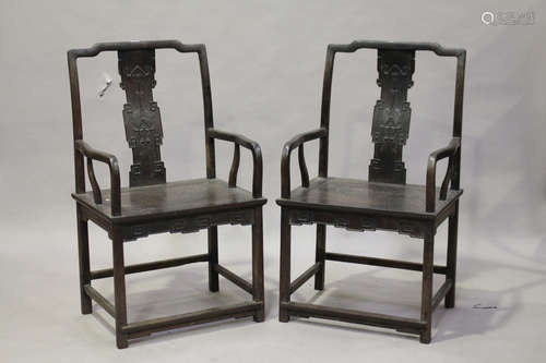 A pair of Chinese hardwood armchairs, 20th century, each shaped top rail above a splat back,