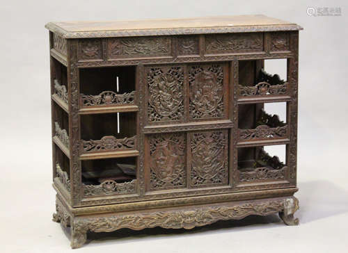 A Chinese carved hardwood side cabinet, late Qing dynasty, fitted with an arrangement of two drawers