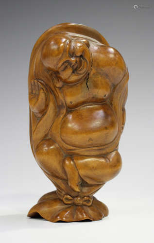 A Japanese carved boxwood figure of Hotei, 20th century, modelled standing with his sack, height