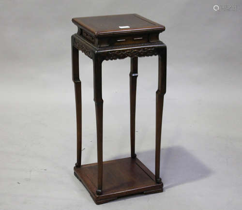 A Chinese hardwood stand, early 20th century, the square panelled top above a shaped scroll apron,