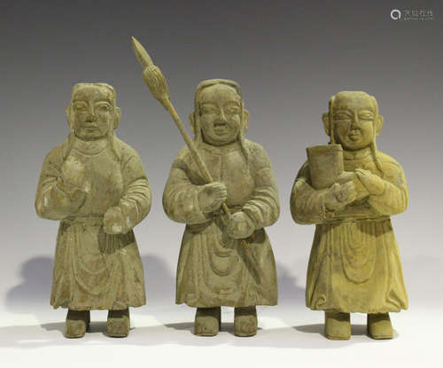 A group of three Chinese tribal carved wood funerary figures, each modelled standing wearing a