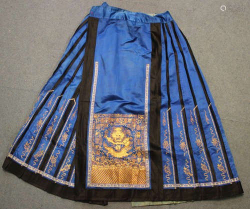 A Chinese blue silk pleated apron skirt, late Qing dynasty, the front and back finely worked in gilt