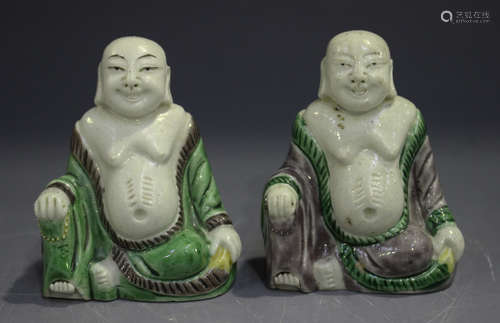 A pair of Chinese famille verte enamelled biscuit porcelain figures of Buddha, Kangxi period, each