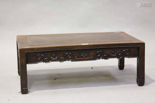 A Chinese hardwood rectangular low table, early 20th century, the panelled top above a shaped