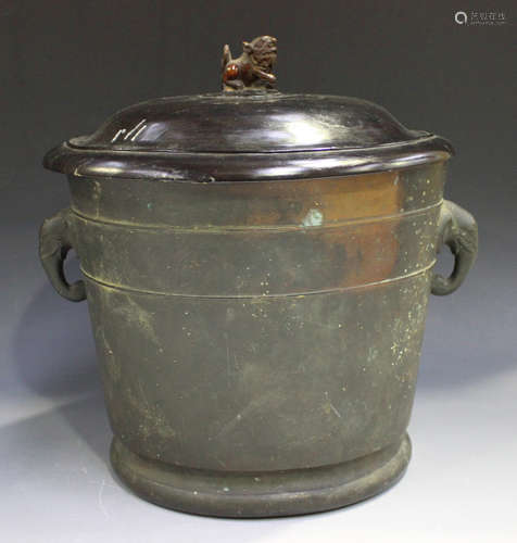 A Chinese brown patinated bronze jar, Qing dynasty, of tapered cylindrical form flanked by a pair of