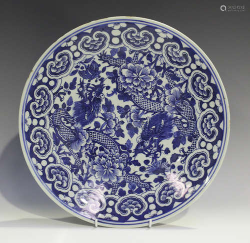 A Chinese blue and white porcelain circular dish, late 19th century, painted with two dragons amidst