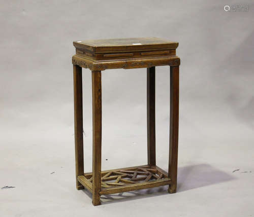 A Chinese elm stand, late Qing dynasty, the rectangular panelled top above a scroll carved frieze,