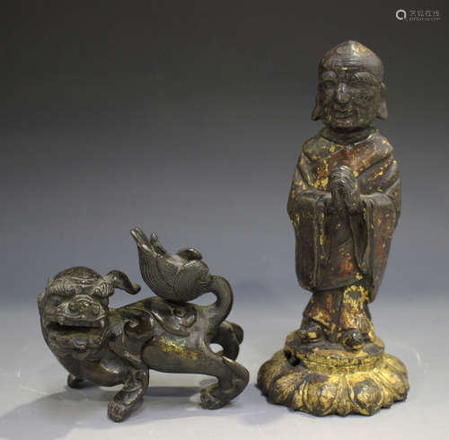 A Chinese bronze figure of a luohan, Ming dynasty, modelled standing with hands folded in prayer, on