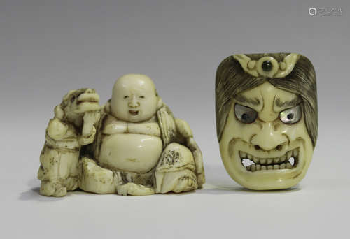 A Japanese carved ivory netsuke, Meiji period, modelled as Hotei seated beside a boy and