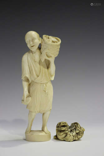 A Japanese carved ivory okimono netsuke, 19th century, modelled as a Buddhistic lion with left paw