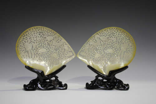 A pair of Chinese carved and pierced mother-of-pearl shells, 20th century, each decorated with a