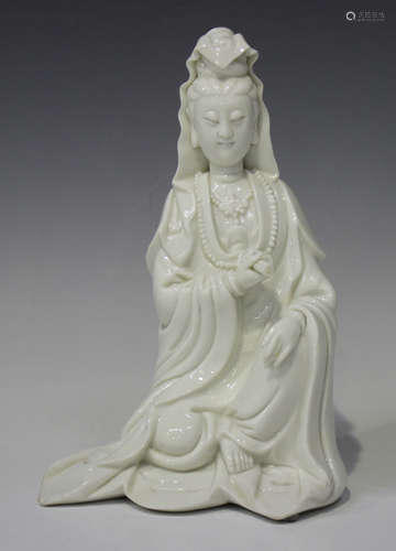 A Chinese blanc-de-Chine porcelain figure of Guanyin, Qing dynasty, modelled seated wearing a long