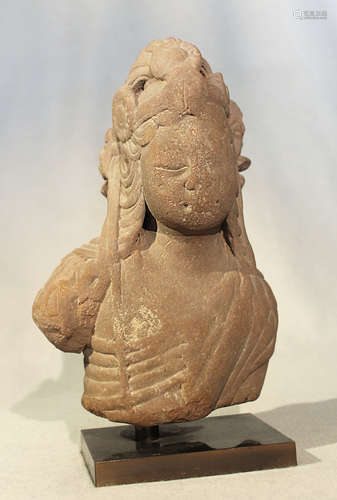 An Indian carved pink sandstone fragmentary head and upper torso of Shiva,