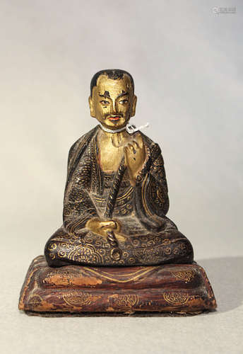 A Tibetan painted wood seated figure of a monk, 18th/19th century,