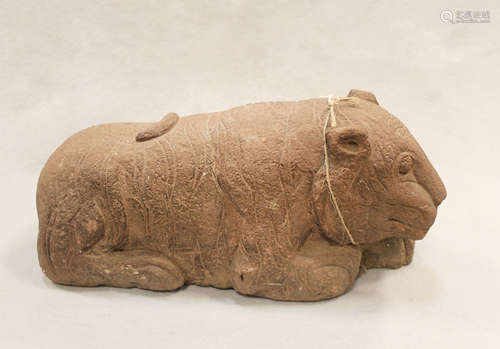 A Chinese red sandstone recumbent tiger, perhaps Han Dynasty, with striped coat,