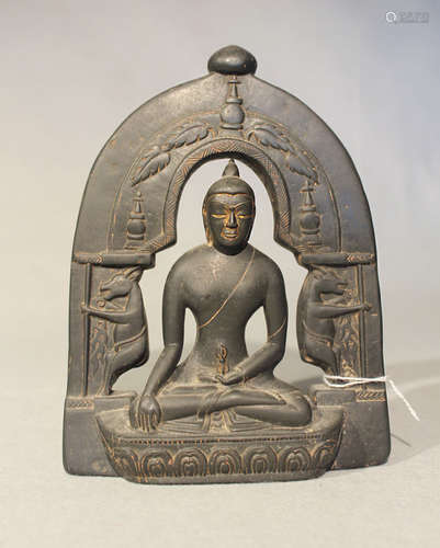 A Nepalese black polished stone seated Buddha with arched aureole, probably 20th century,