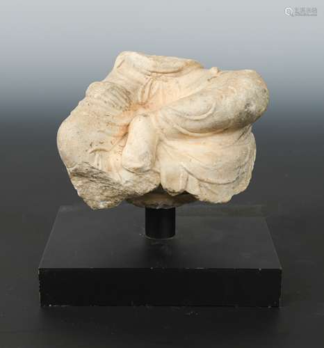 A Chinese white marble fragmentary figure of a seated Buddhist deity, in 6th/7th century style,