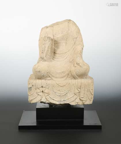 A Chinese grey stone seated Buddhist deity, headless, perhaps Wei Dynasty,