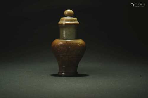 A Chinese green and russet jade archaistic vase and cover