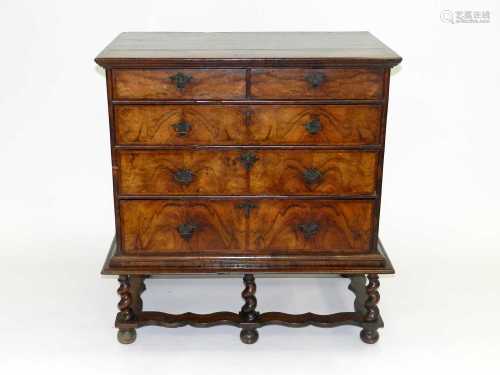 An early 18th century walnut veneered chest, of two short and three long graduated drawers,