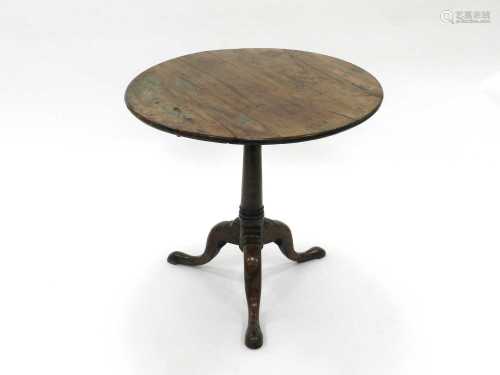 A George III yew tripod table, with a three-piece circular tilt-top and downswept legs terminating