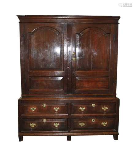 An early 18th century oak livery cupboard, the cyma recta cornice above two large arched fielded