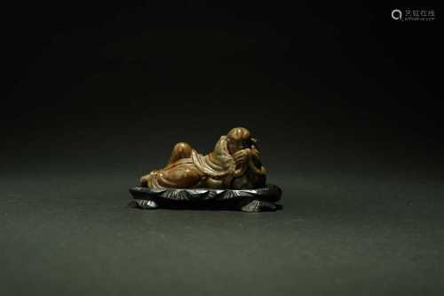 A Chinese green and russet soapstone figure of a reclining Buddha and tiger