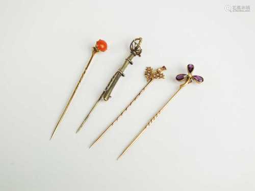 A collection of four stick pins