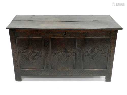 A 17th century coffer, later carved, the twin-plank top later hinged in the middle, 123cm wide x