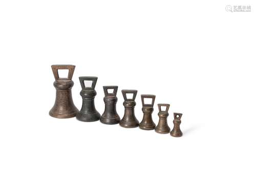 A harlequin set of seven English bronze and iron weights