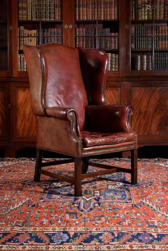 A mahogany and red leather upholstered wing armchair
