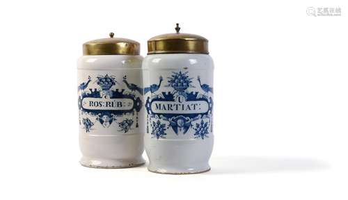 Two Dutch Delft blue and white cylindrical drug jars and gilt-metal covers