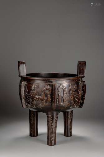 A CHINESE ZITAN CARVED 'TAOTIE' TRIPOD DING