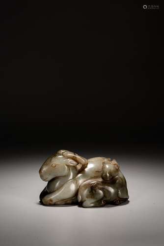 A CHINESE CELADON JADE CARVED SEATED RAM