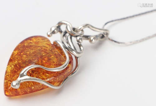 AN AMBER CARVED HEART SHAPE PENDANT