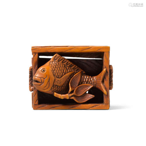 A boxwood netsuke of a fish in a box By Reigen Geijo (b. 1935)