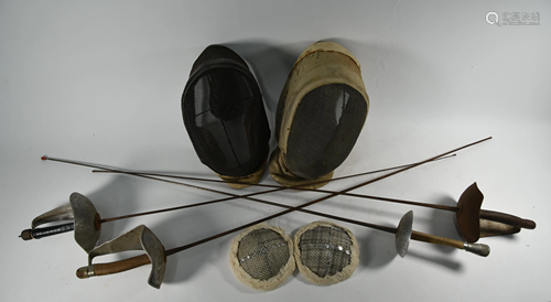 Two vintage fencing masks, a pair of breast-guards and