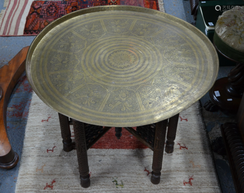 An old Eastern circular engraved brass tray top table
