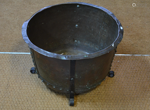 An old studded copper tub raised on wrought feet