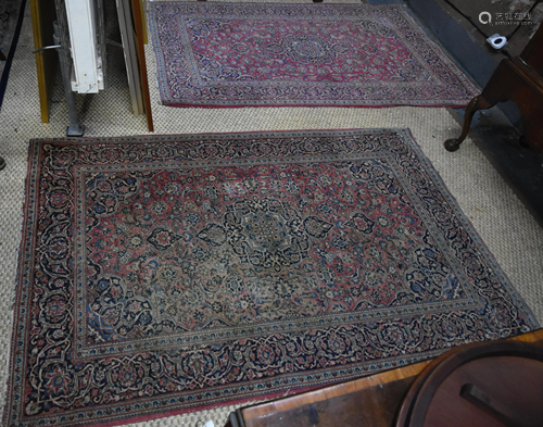 A companion pair of antique Persian Kashan rugs, first