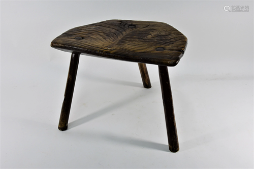 An antique rustic elm dairy stool